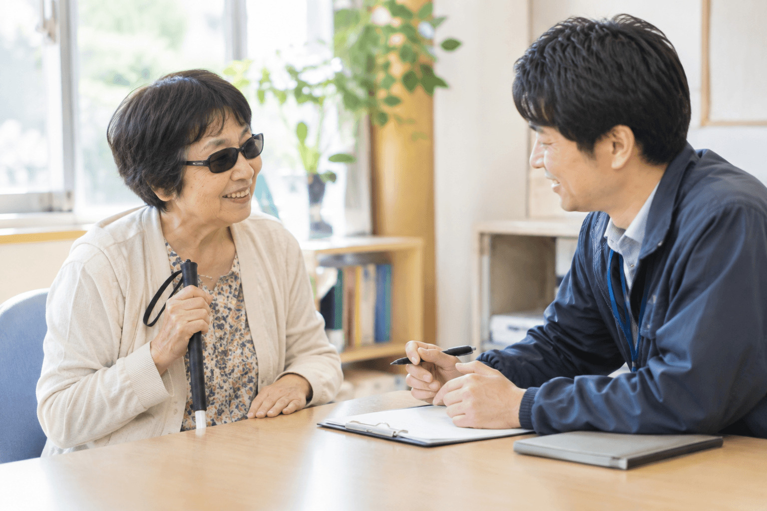 相談員が利用者と向かい合い、机で相談に応じている様子